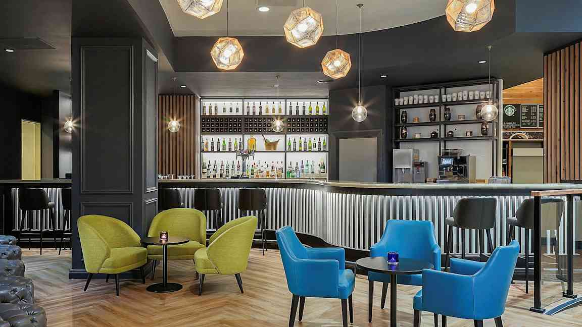 En modern bar med färgglada sittmöbler och belysning. (AI-genererad text)