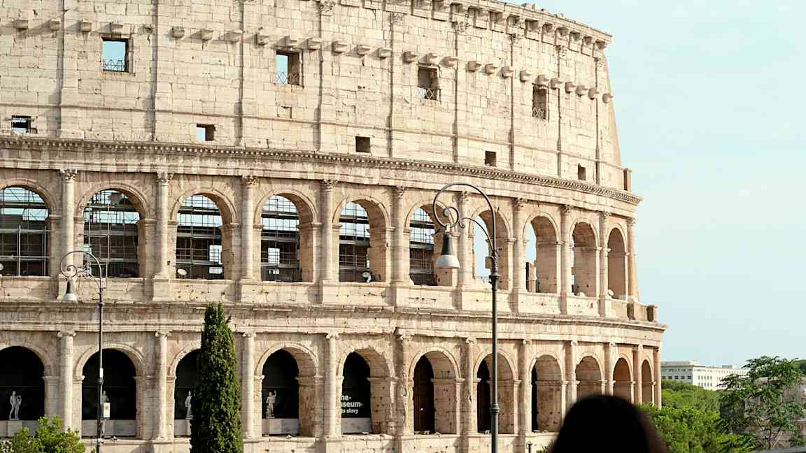 Bild av Colosseum i Rom, Italien, med en kvinna i förgrunden. (AI-genererad text)