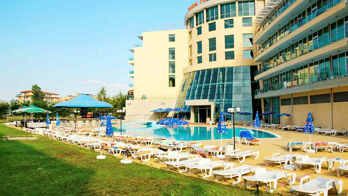 Hotellets poolområde med solstolar och parasoller. (AI-genererad text)