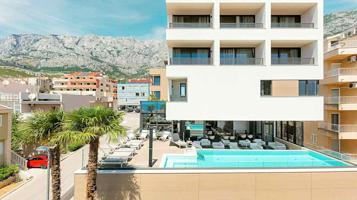 Modern byggnad med pool och palmer framför. (AI-genererad text)