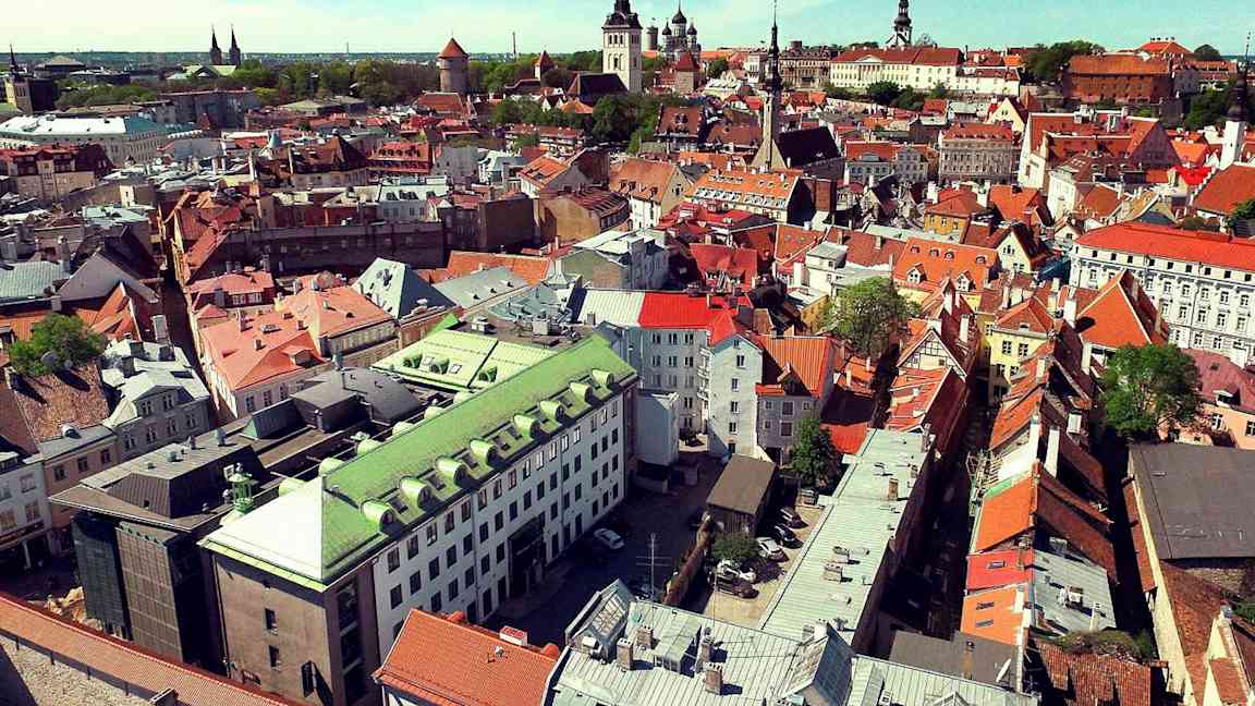 Flygvy över en stad med äldre byggnader i olika färger. (AI-genererad text)