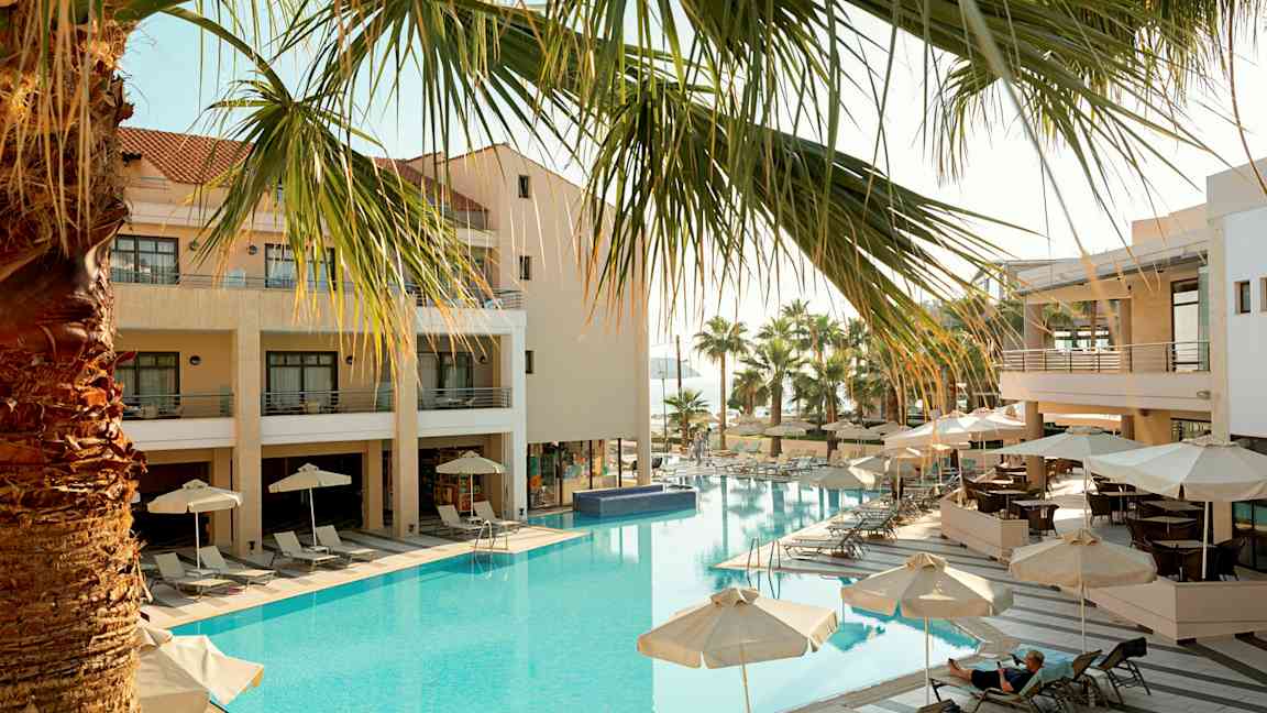 Hotell med utomhuspool, solstolar och parasoller. (AI-genererad text)