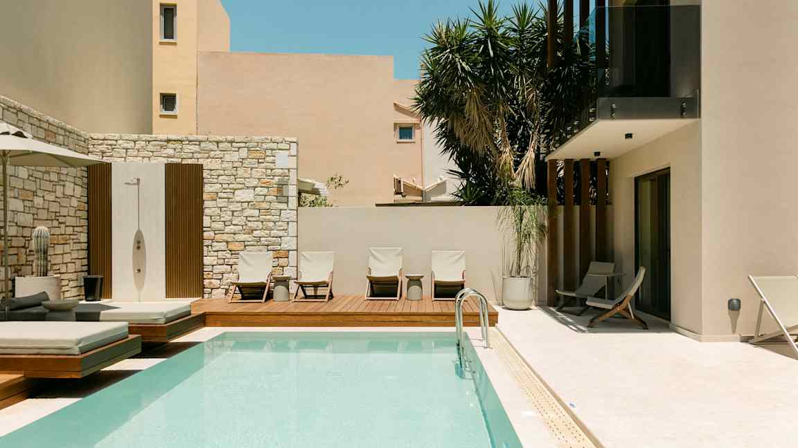 Utomhuspool och solstolar vid en modern byggnad. (AI-genererad text)