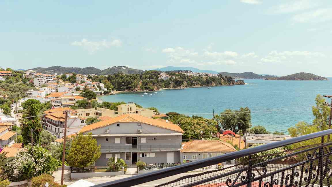 Utsikt över en kuststad med röda tak och havet i bakgrunden. (AI-genererad text)