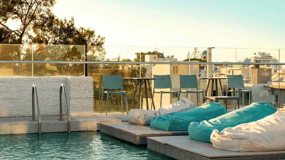 En pool med sittplats vid solnedgång. (AI-genererad text)