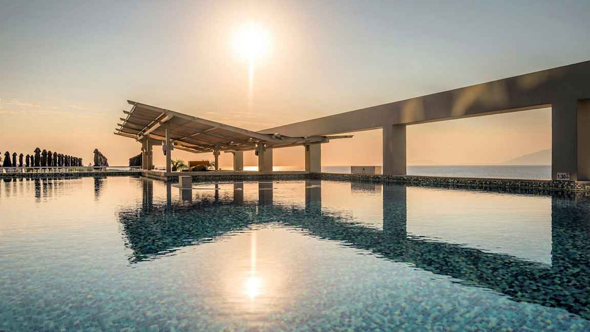 En pool med utsikt över havet och en soluppgång. (AI-genererad text)