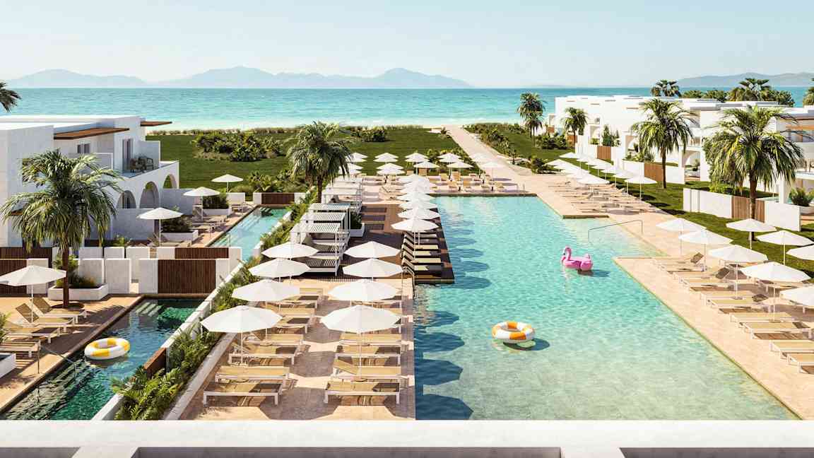 Bild av en semesterresort med pooler, solstolar och parasoller nära havet. (AI-genererad text)