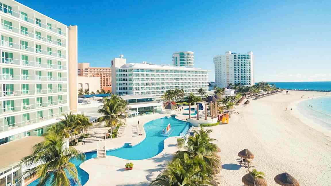 Bild av hotell vid stranden med pool och palmer. (AI-genererad text)