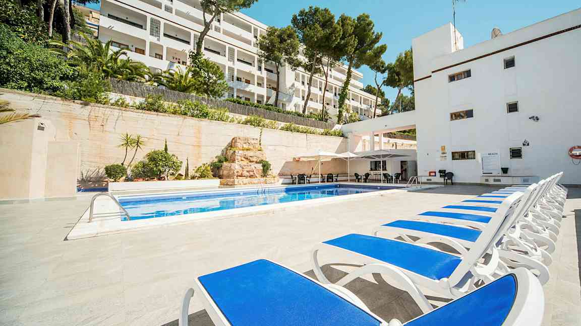 Solstolar vid en pool med hotellbyggnad i bakgrunden. (AI-genererad text)