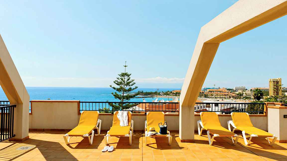 Terrass med solstolar och havsutsikt. (AI-genererad text)