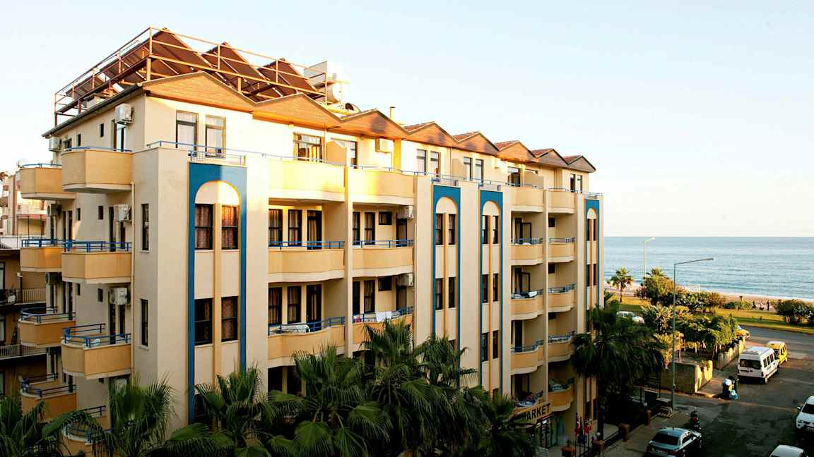 Bild av en fler våningsbyggnad med balkonger nära havet. (AI-genererad text)