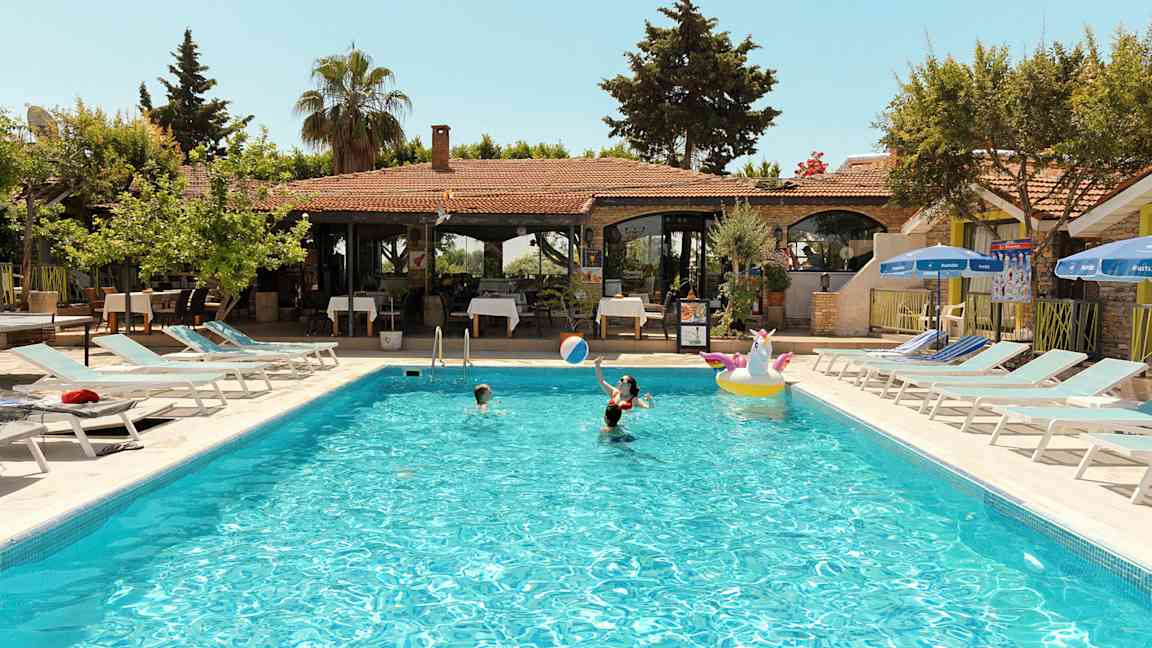 Utomhuspool med människor som badar vid en semesteranläggning. (AI-genererad text)