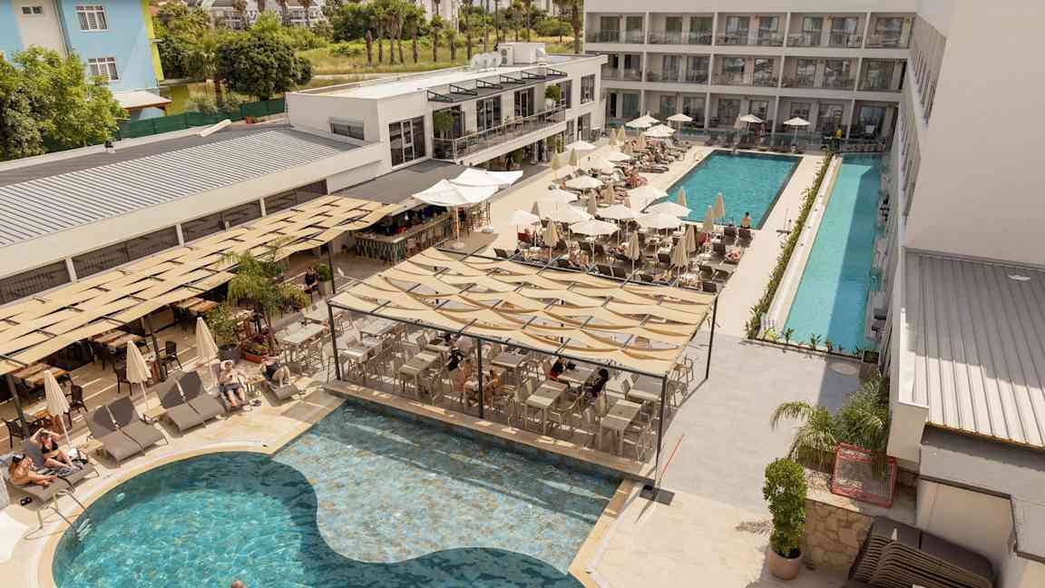 Hotellets poolområde med solstolar, parasoller och en servering vid poolen. (AI-genererad text)