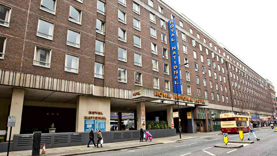 En bild av Royal National Hotel i London, byggnaden är brun och har flera fönster. (AI-genererad text)