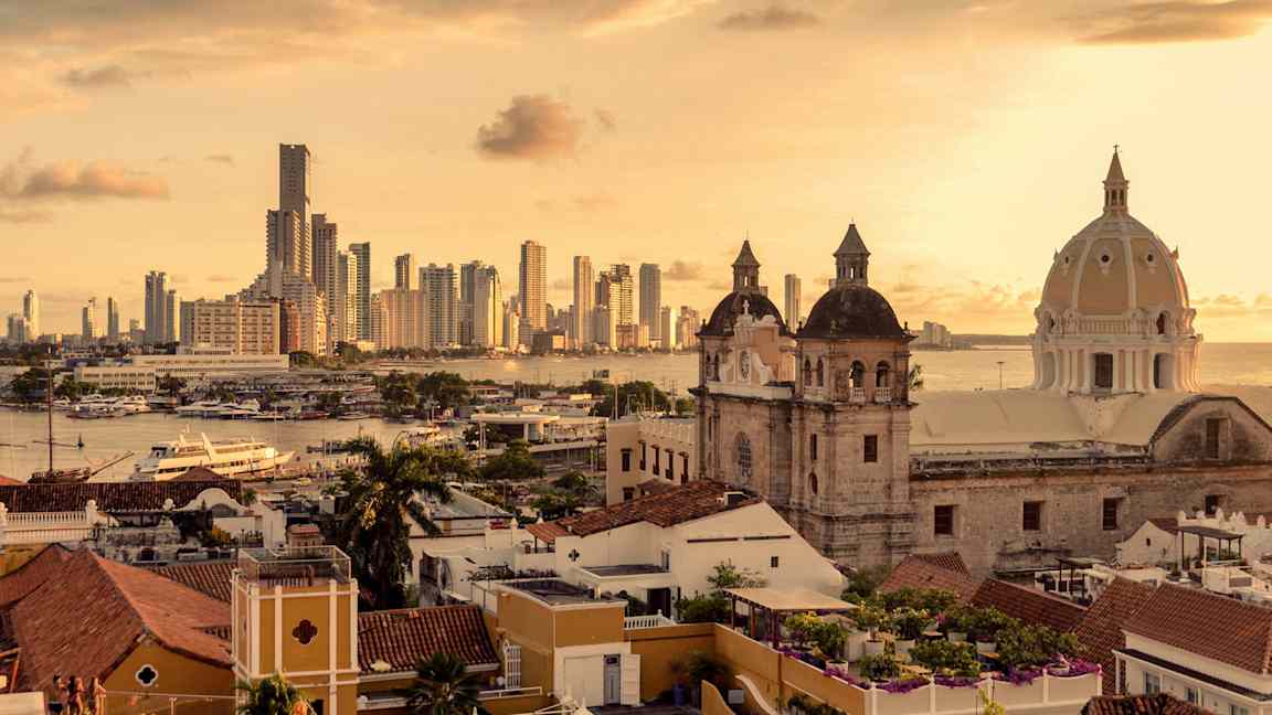 En stad med moderna byggnader, historisk arkitektur och havet i bakgrunden. (AI-genererad text)