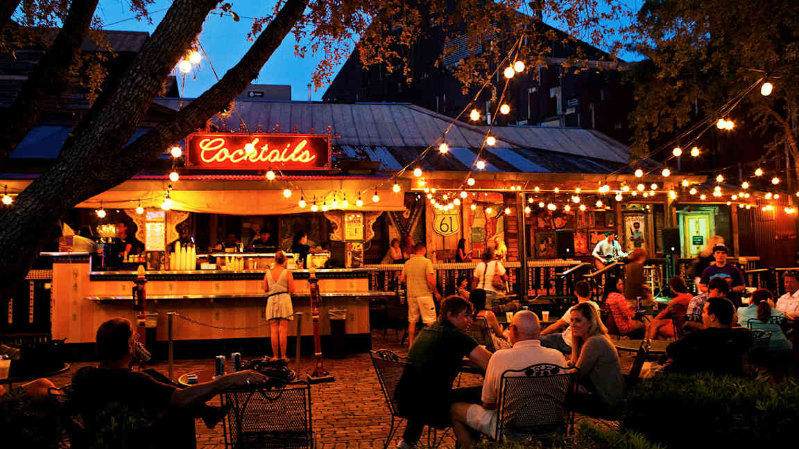 En utomhusbar med belysning och gäster. (AI-genererad text)