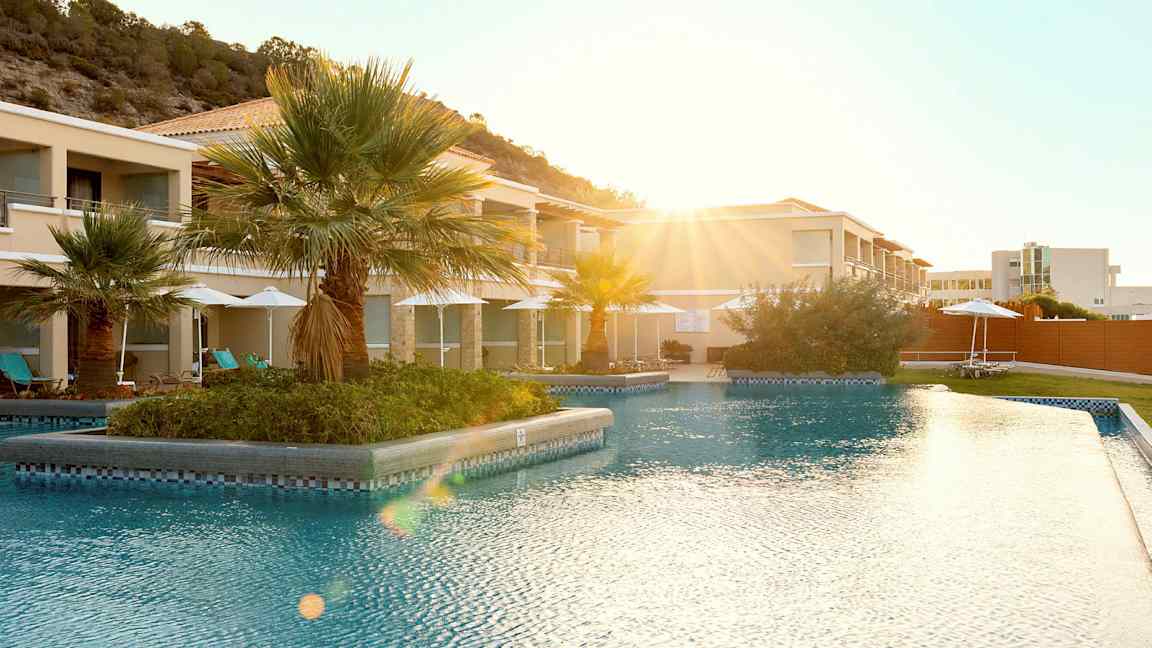 Utomhuspool vid en resort med palmer i bakgrunden. (AI-genererad text)