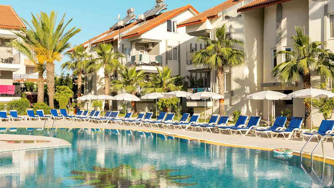 Utomhuspool vid hotell med solstolar och parasoller. (AI-genererad text)