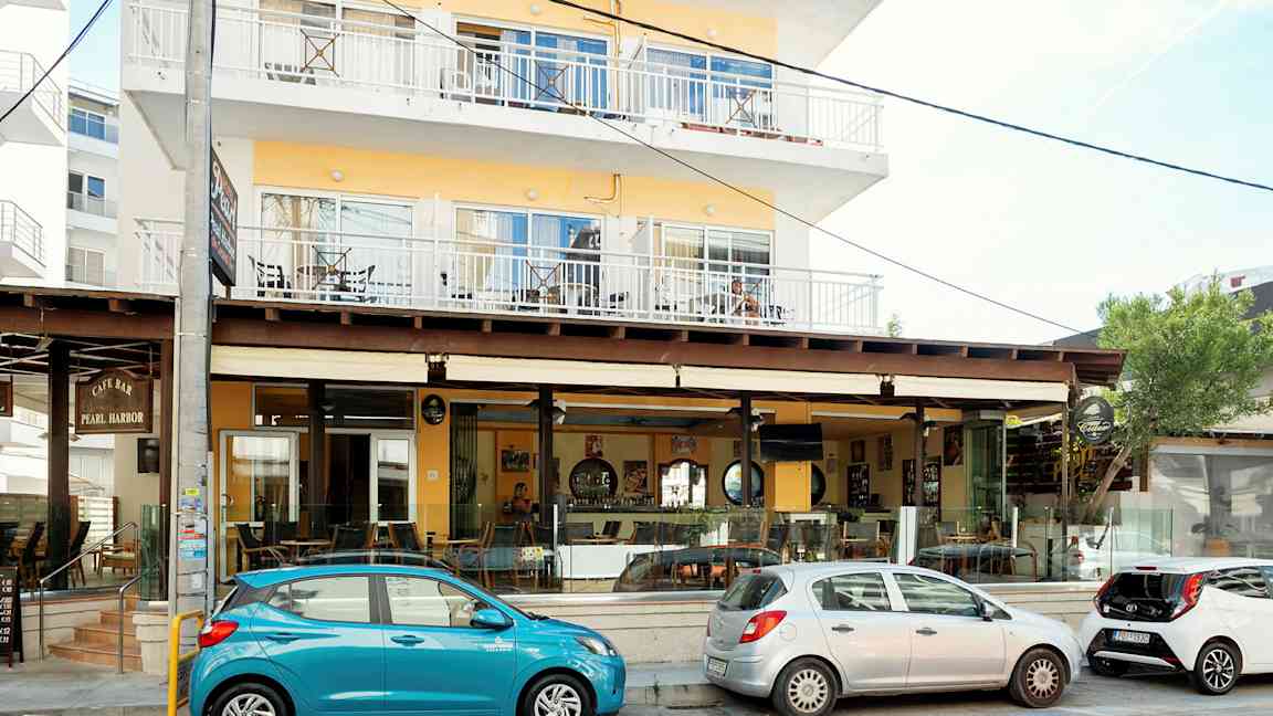 Flerfamiljshus med café längs gatan. (AI-genererad text)