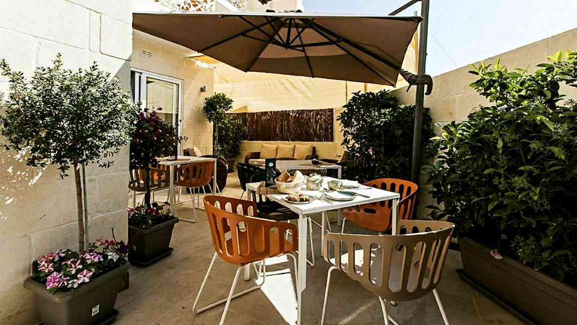 En terrass med utemöbler, parasoll och växter. (AI-genererad text)