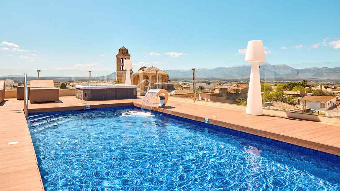 Utomhuspool med utsikt över staden och bergen. (AI-genererad text)