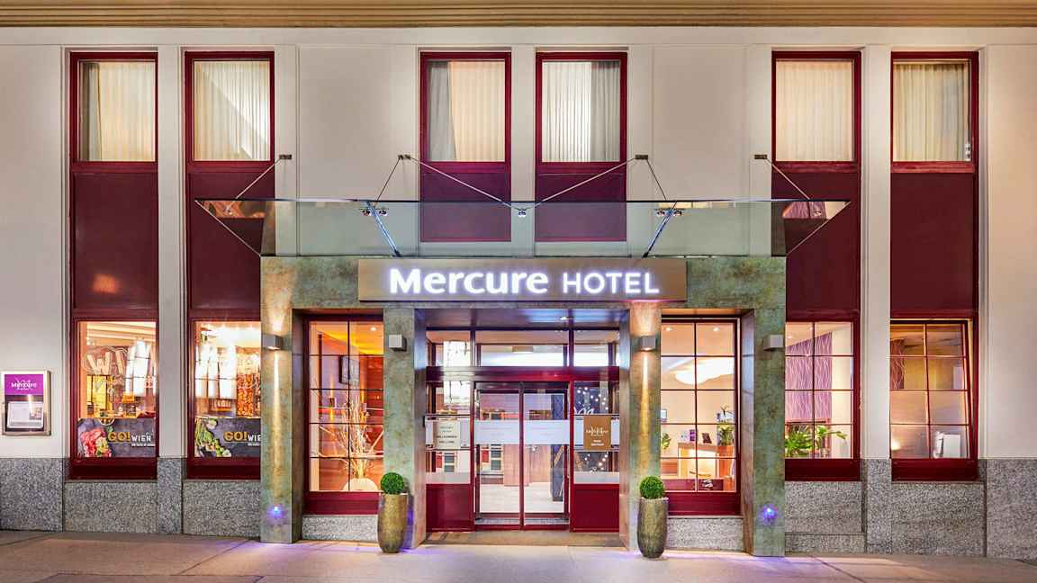 Entrén till Mercure Hotel med skylt och fasad. (AI-genererad text)