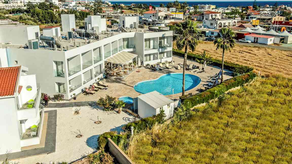 Flygvy av hotellområde med pool och omgivande byggnader. (AI-genererad text)