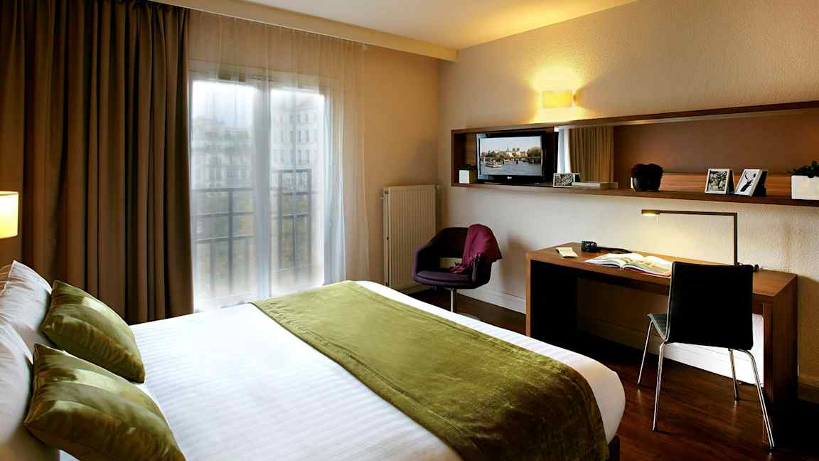 Hotellrum med dubbelsäng och arbetsbord. (AI-genererad text)