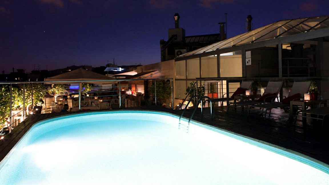 Upplyst pool på ett tak vid skymning. (AI-genererad text)