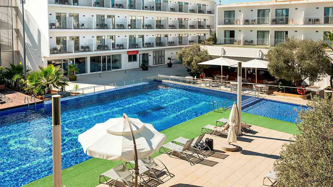 Bild av en hotellbyggnad med flera våningar. Framför byggnaden finns en rymlig pool och solstolar under parasoller. (AI-genererad text)