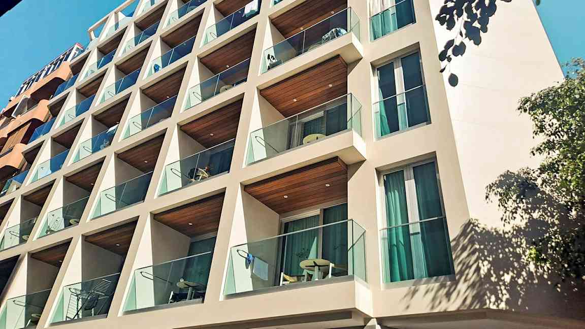 En byggnad med balkonger och glasräcken. (AI-genererad text)