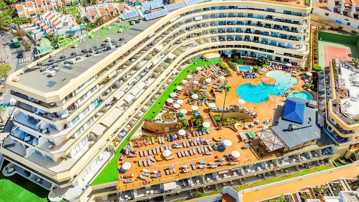 Bild av ett hotell med poolområde och omgivande semesterbostäder. (AI-genererad text)