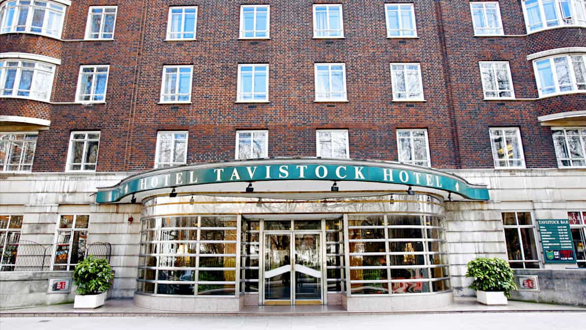 Hotellbyggnad i tegel med skylt Tavistock Hotel och huvudentré. (AI-genererad text)