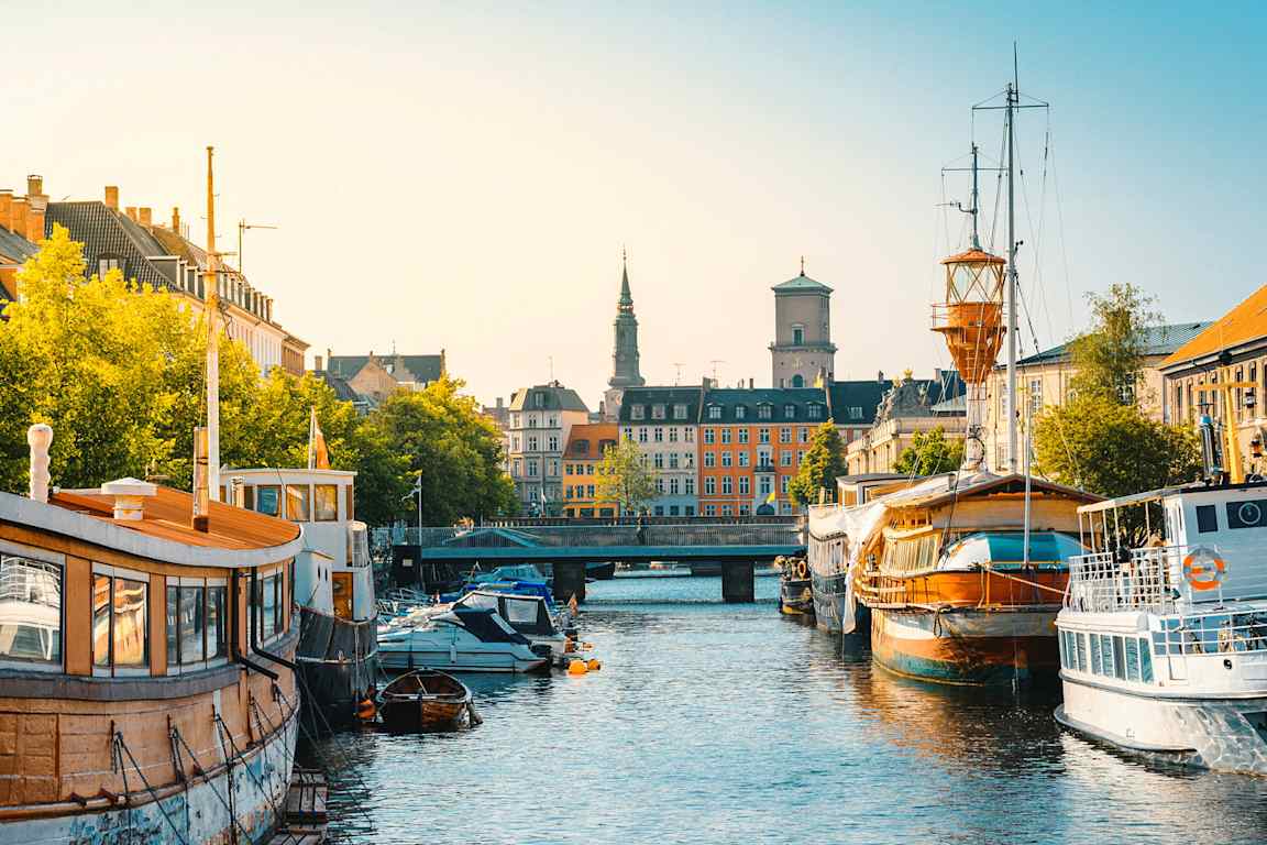 En stadskanal med båtar längs kanterna och byggnader i bakgrunden. (AI-genererad text)