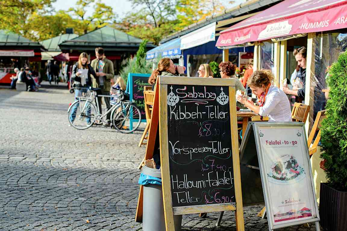 Ett gatukafé med uteservering och en meny på svarta tavlan. (AI-genererad text)