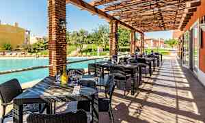 Uteservering med bord och stolar vid en pool. (AI-genererad text)