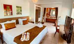 Dubbelrum med säng, konst på väggarna och öppet badrum. (AI-genererad text)