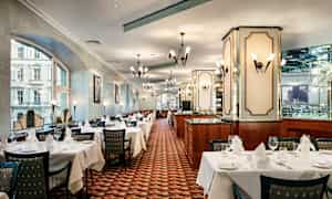 Ett elegant inrett restauranginteriör med dukade bord, stolar och smakfull belysning. (AI-genererad text)