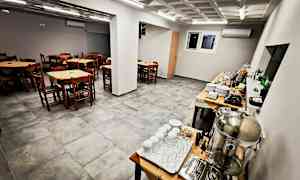 Ett matsal med trästolar och bord samt en buffé med serveringsutrustning. (AI-genererad text)