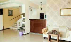 Ljus hotellreception med soffa, träbord och marmorerad trappa. (AI-genererad text)