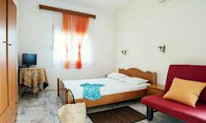 Bild av ett hotellrum med enkelsäng, röd soffa och små möbler. (AI-genererad text)