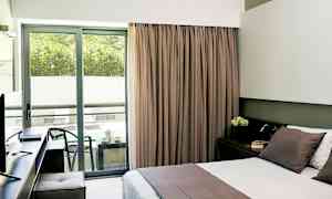 Hotellrum med dubbelbädd och balkong med sittmöbler. (AI-genererad text)