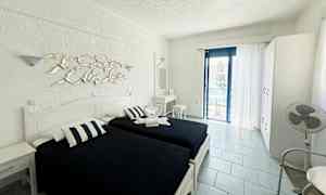 Rum med två enkelsängar, vit inredning och en balkong med havsutsikt. (AI-genererad text)