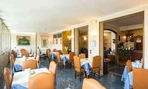 Restaurangmatsal med bord klädda med blå dukar och stolar runt. (AI-genererad text)