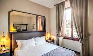 Hotellrum med dubbelsäng, sängbord, spegel och fönster med beige gardiner. (AI-genererad text)