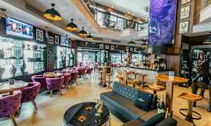 En inbjudande bar med moderna möbler och dekorativa inslag som skapande tavlor och skulpturer. (AI-genererad text)