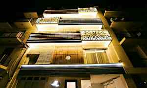 Flerfamiljshus sett nerifrån i nattbelysning. (AI-genererad text)