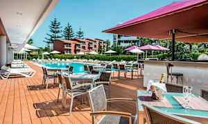 Utomhusområde med pool, solstolar och ett matserveringsområde. (AI-genererad text)