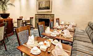 Ett trevligt uppdukat rum med trästolar och dukade bord. (AI-genererad text)