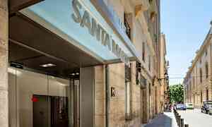 Entrén till ett hotell med texten "Santa Marta" på en skylt och en gata synlig i bakgrunden. (AI-genererad text)